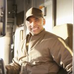 Smiling delivery man sitting in truck